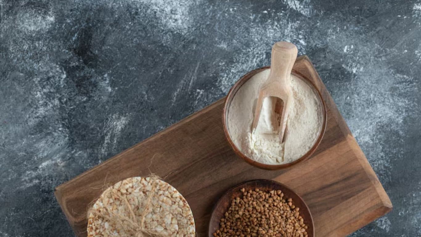 Assorted grains and flour on rustic wooden board
