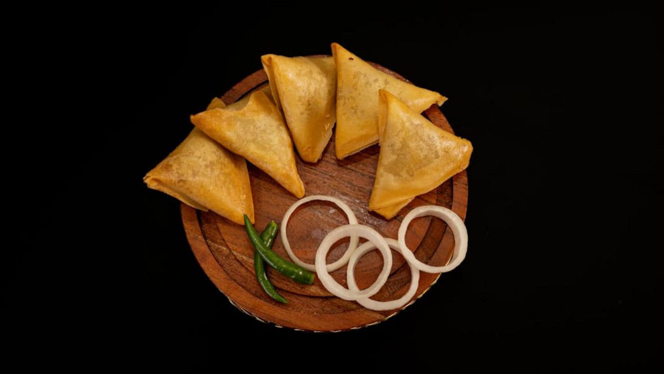 Street food samosa on plate - banner image