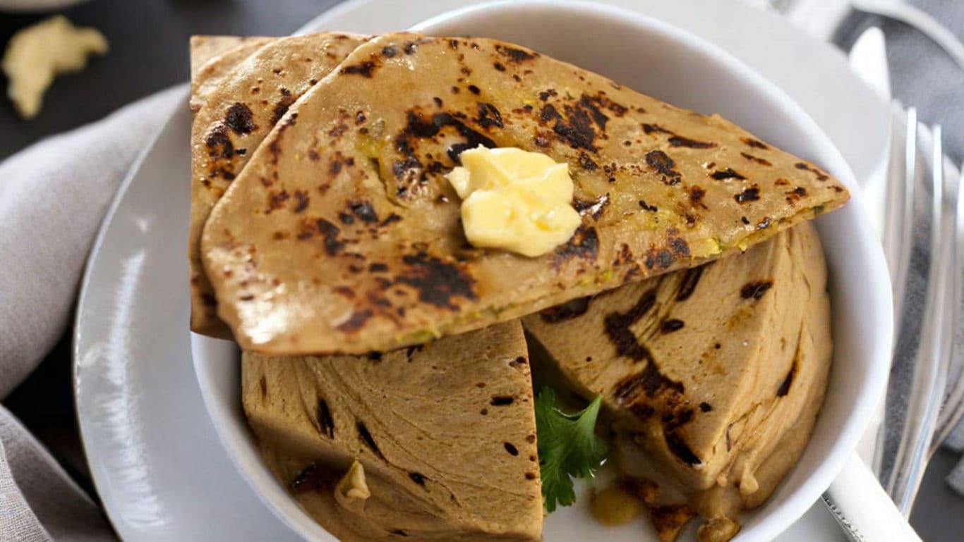 Stuffed flatbread with melting butter on white plate
