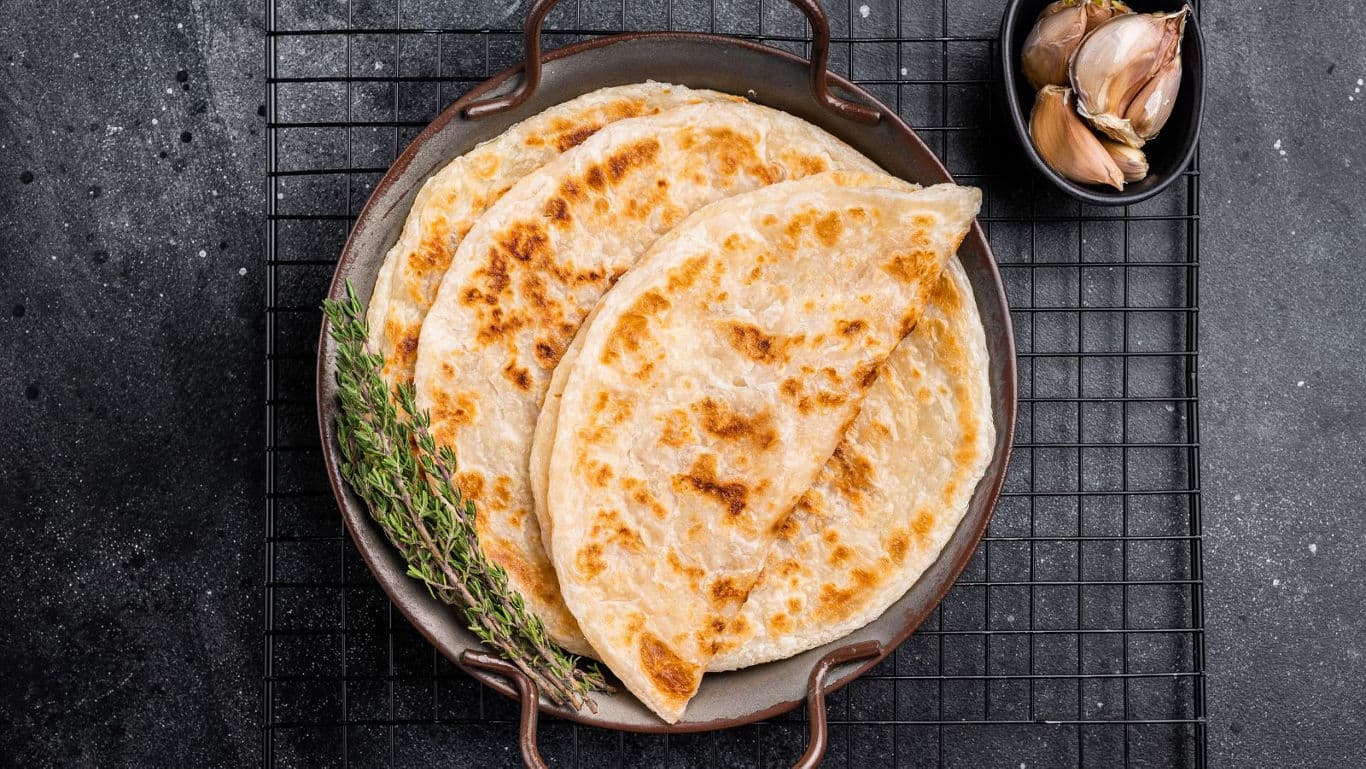 Freshly cooked flatbreads on rustic wire rack