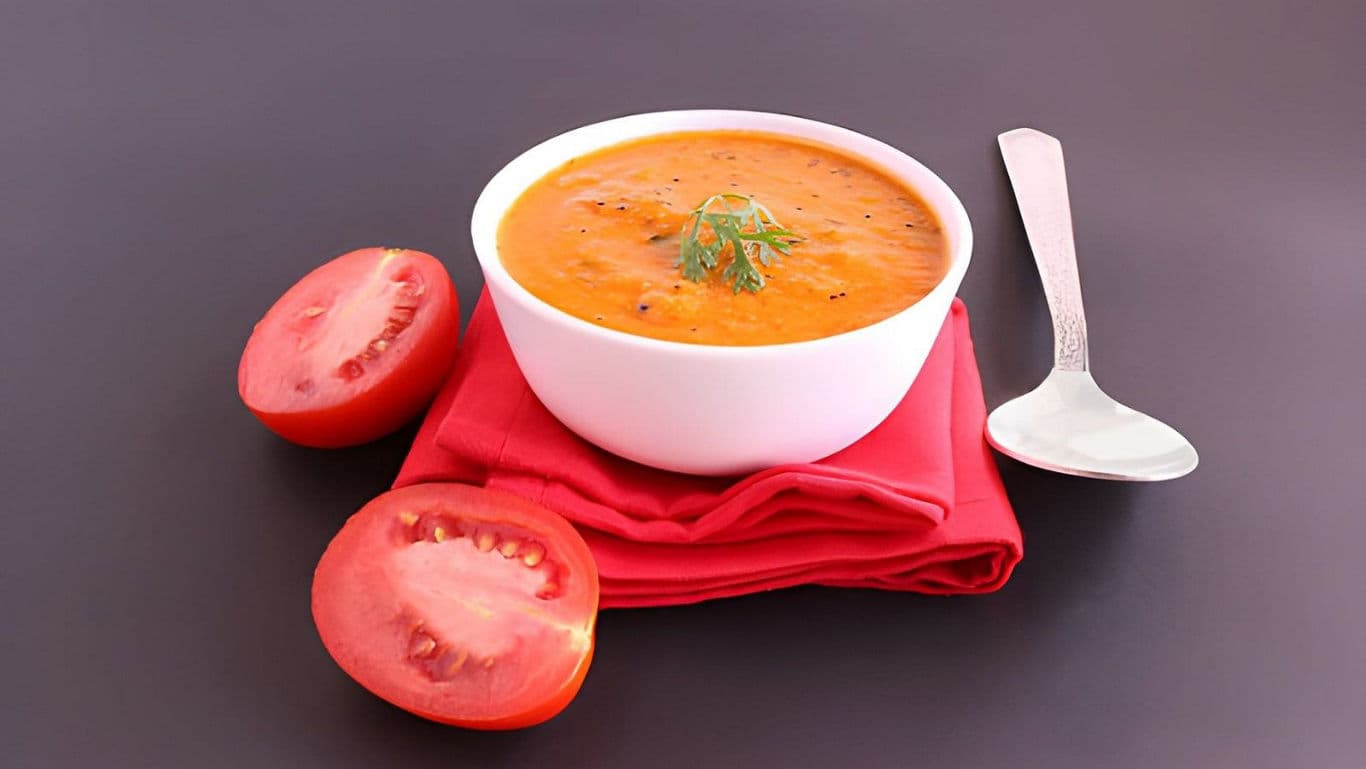 Bowl of tomato soup with fresh tomato halves