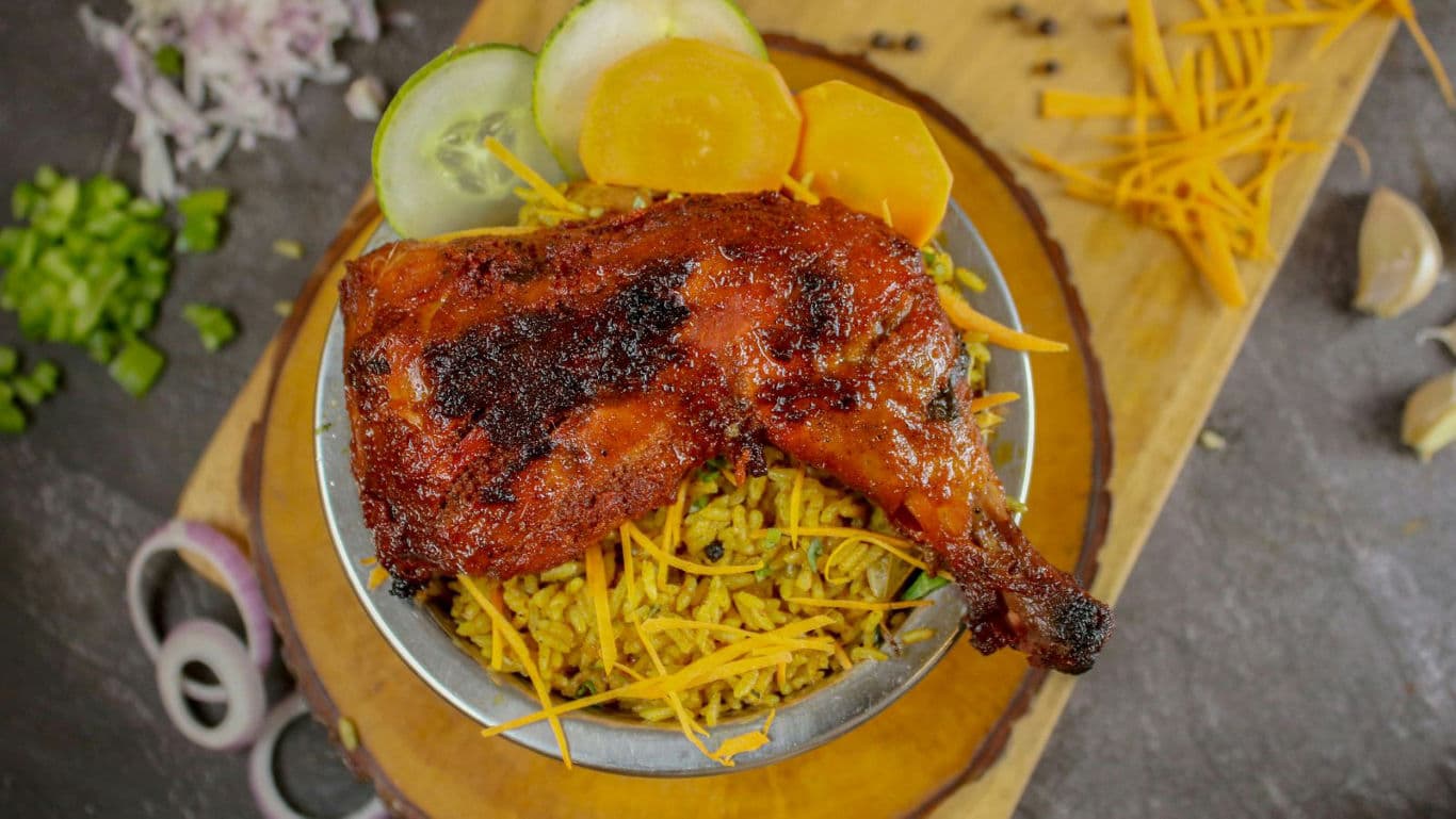 Grilled Chicken Leg Served Over Spiced Rice Bowl
