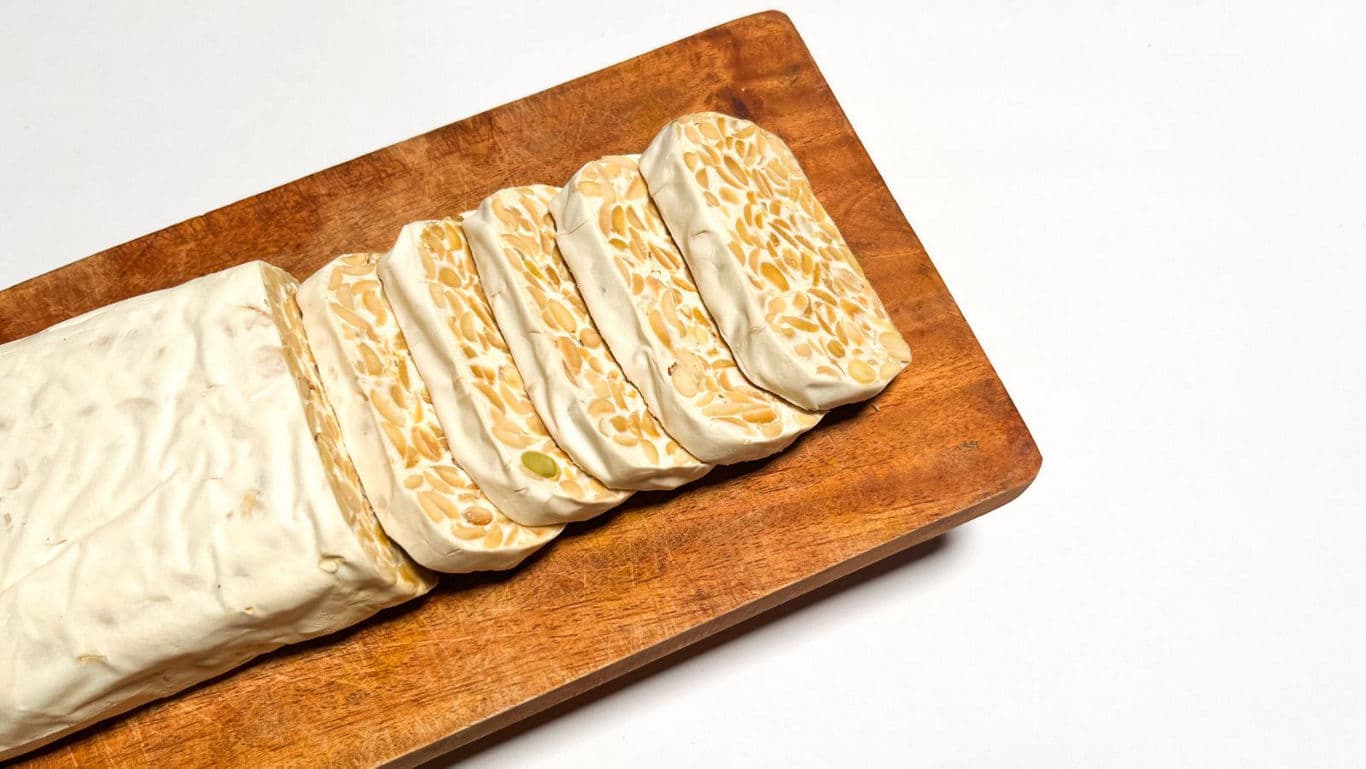 Sliced tempeh on wooden cutting board