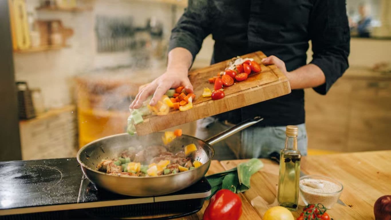 Chef cooking vegetables in modern kitchen