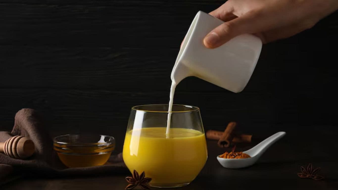 Pouring Milk Into Turmeric Latte With Spices