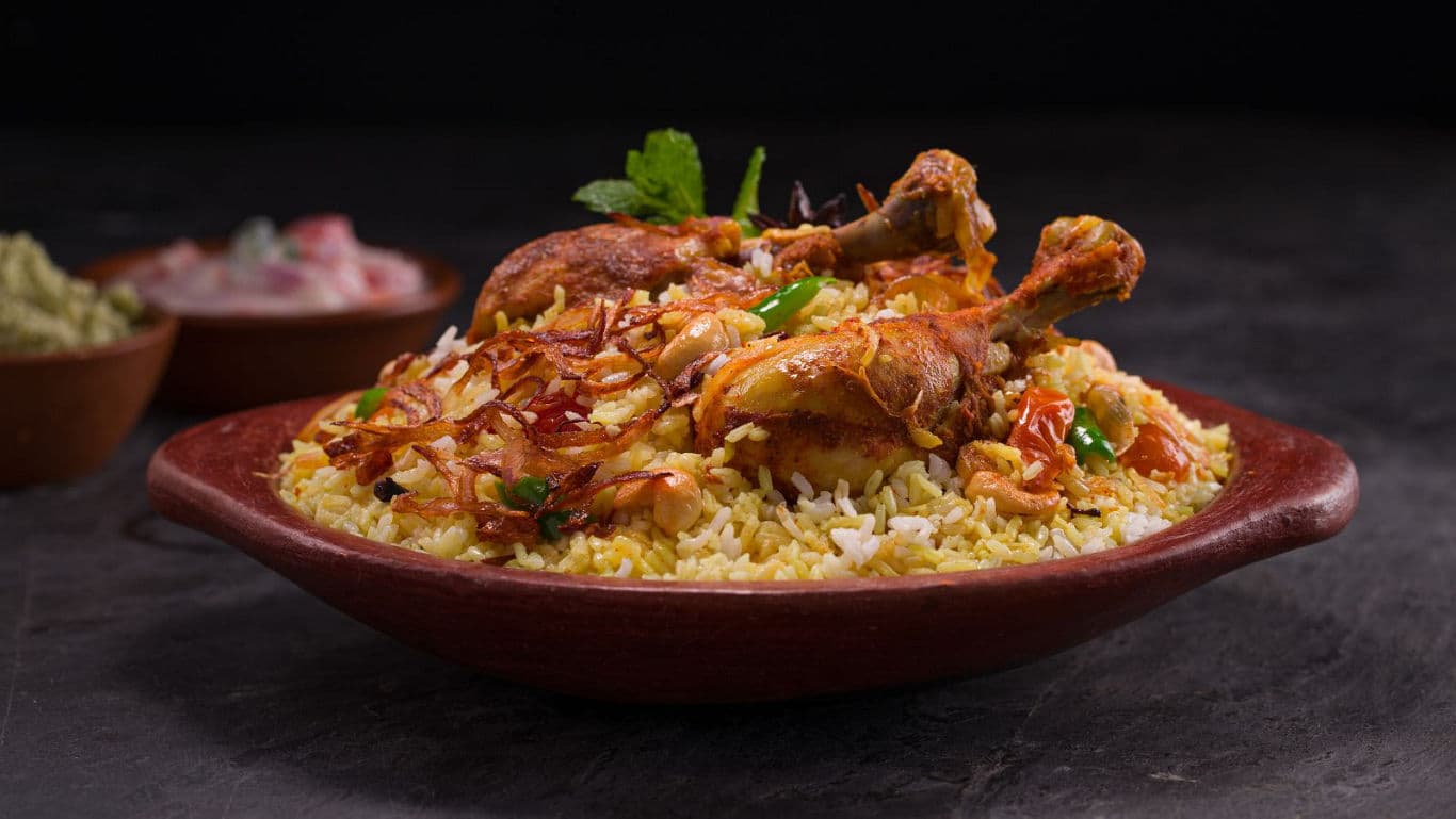 Traditional chicken biryani served in rustic clay bowl