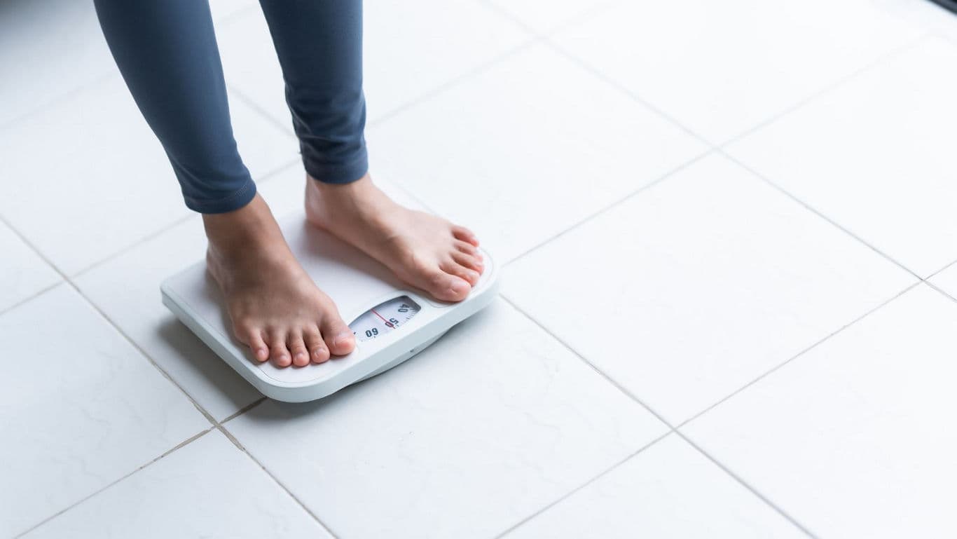 Person standing on digital bathroom scale indoors