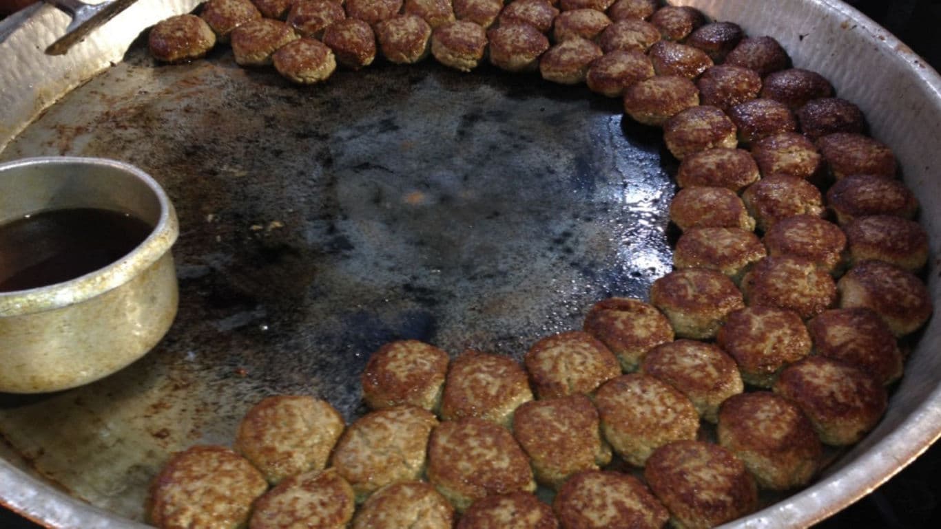 Large Tray of Fried Meatballs Cooking in Oil
