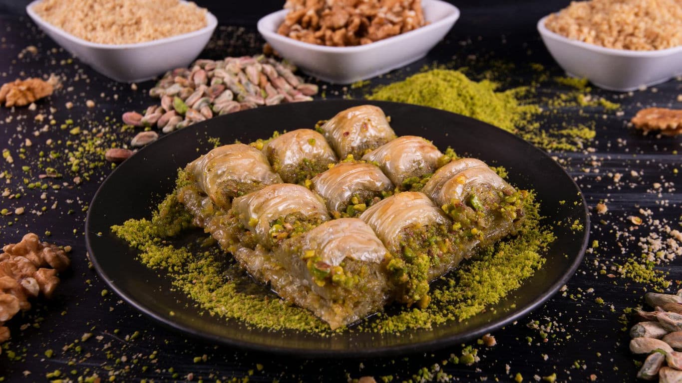 Traditional pistachio baklava squares on black plate