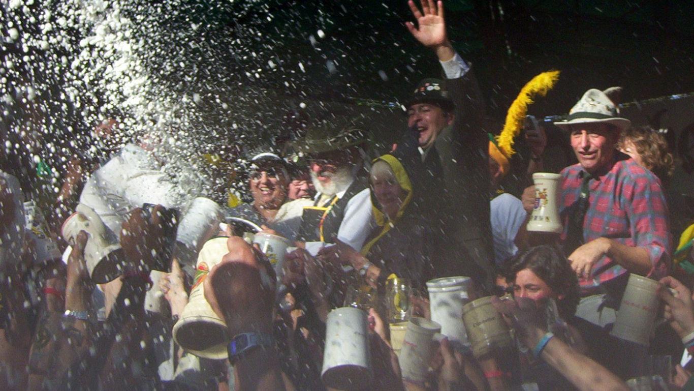 Crowd celebrating with beer mugs outdoors