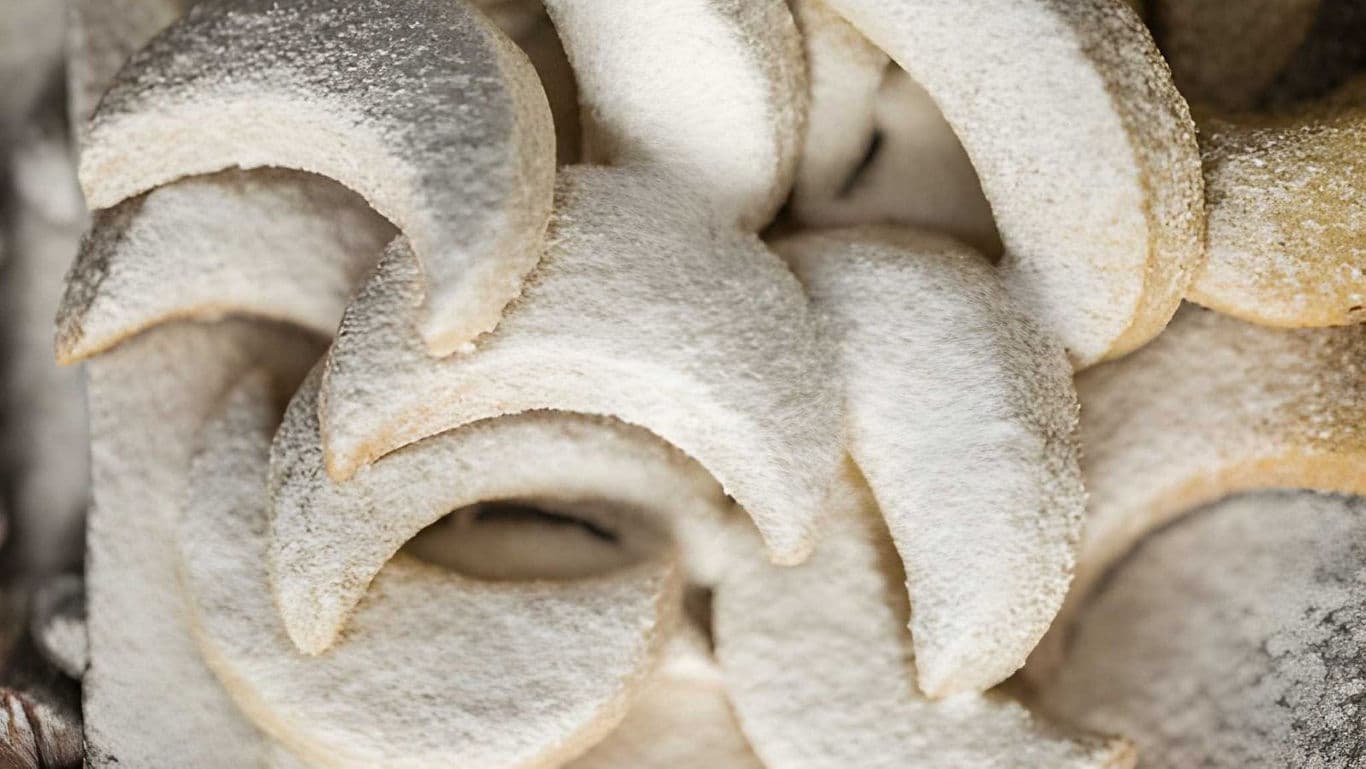 Powdered crescent cookies stacked in close-up view