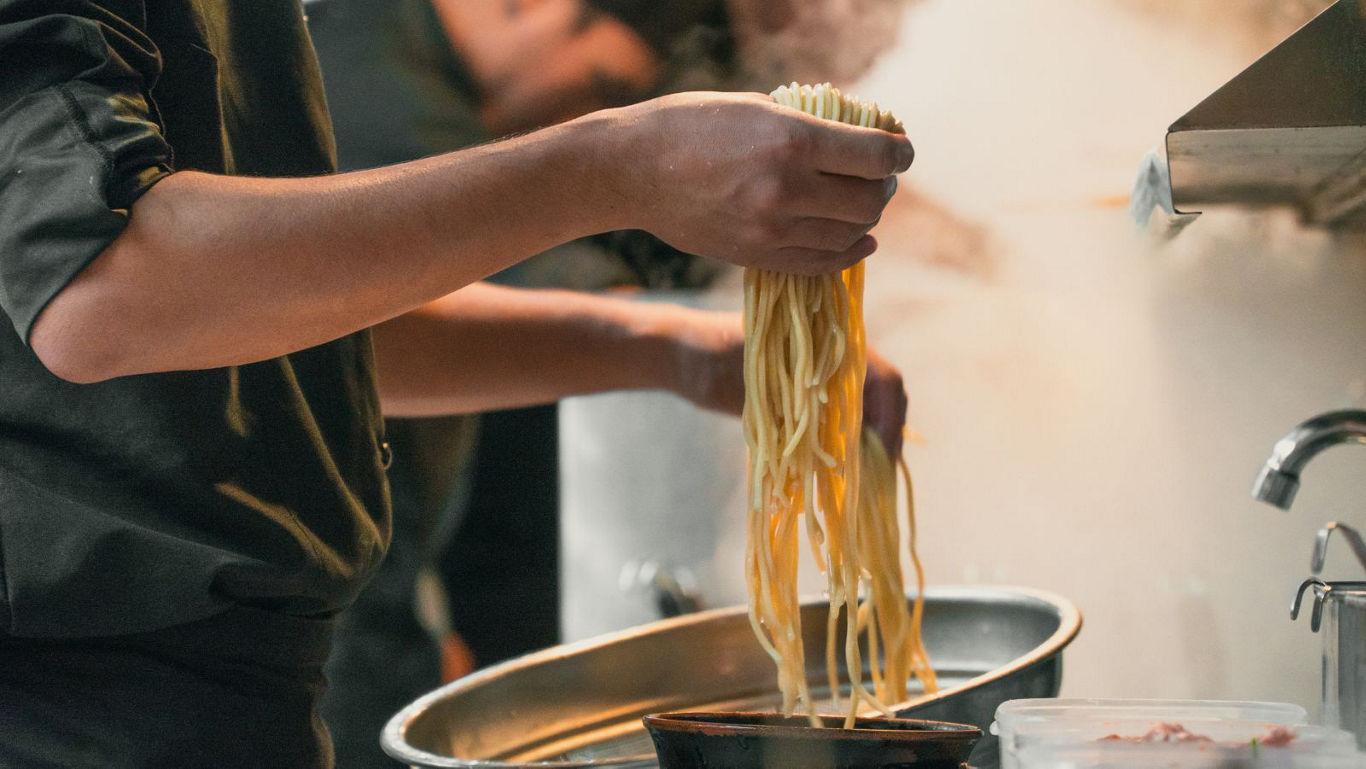 Chef preparing fresh noodles in kitchen