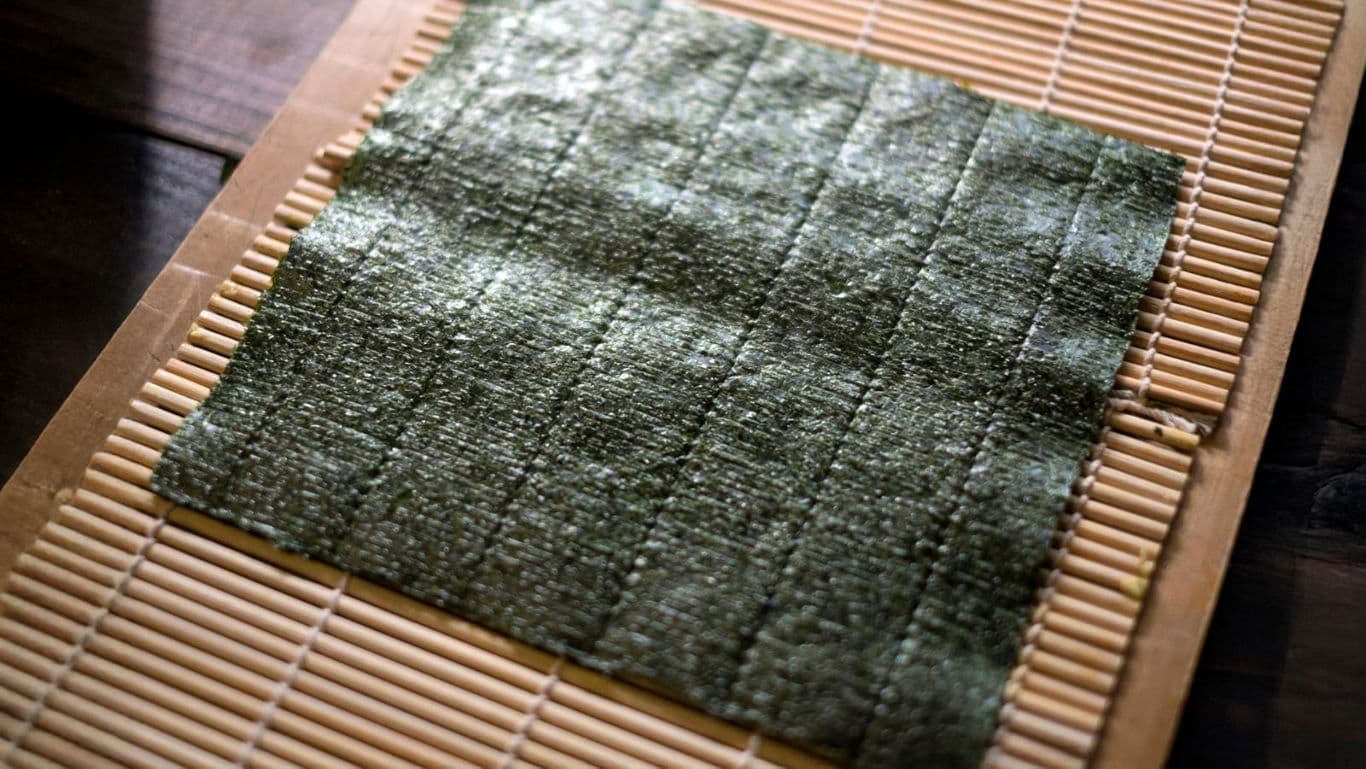 Sheet of nori seaweed on sushi mat