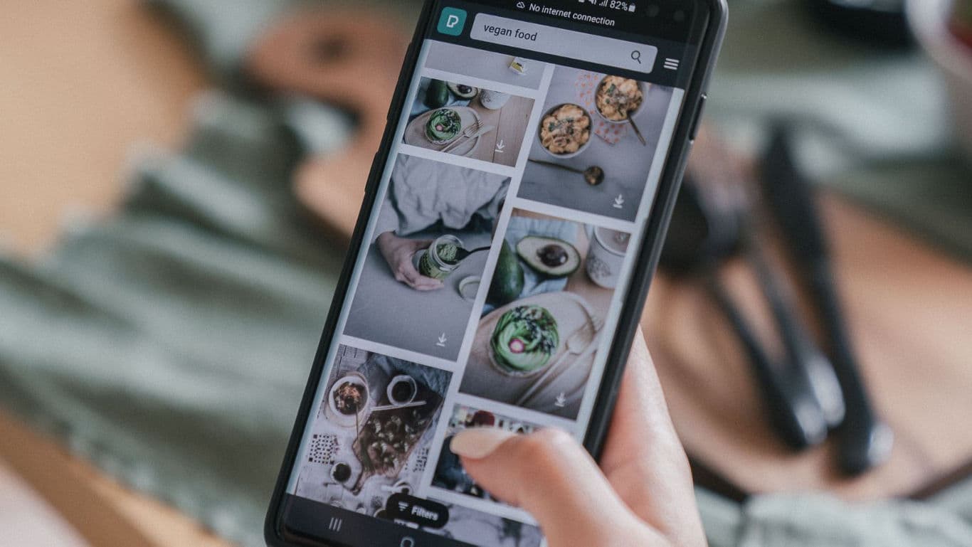 Person browsing vegan food photos on smartphone