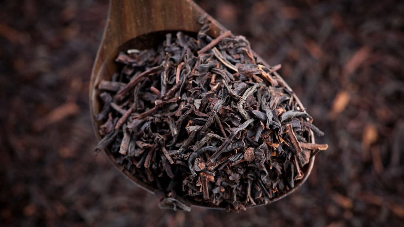 Wooden spoon filled with loose black tea