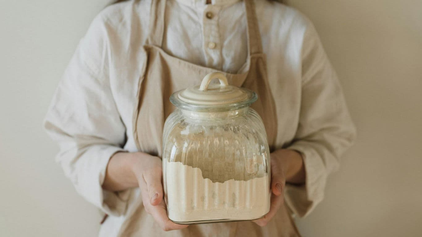 Woman holding glass jar of flour