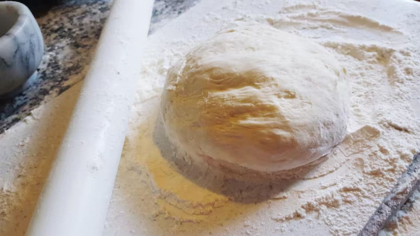 Fresh Dough Ball on Floured Surface with Rolling Pin
