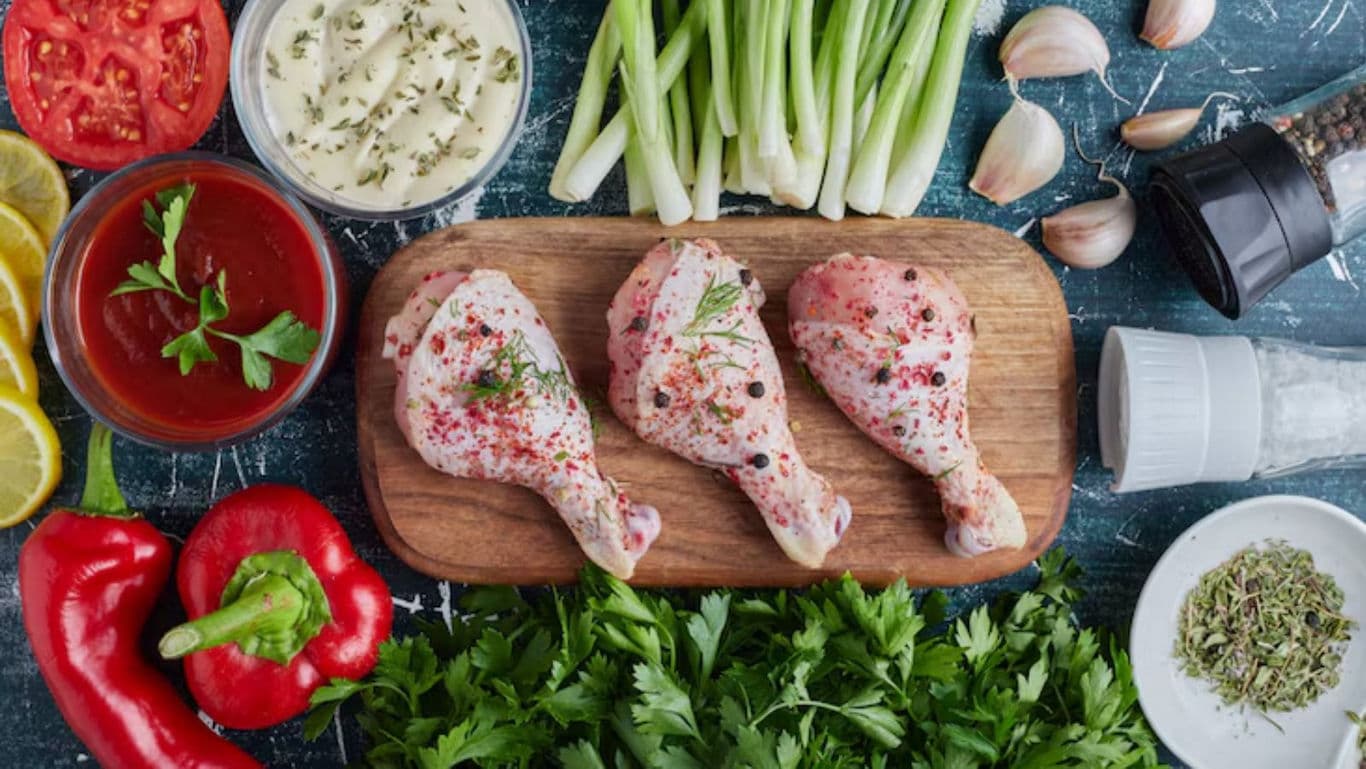 Raw Chicken Drumsticks with Fresh Vegetables and Herbs