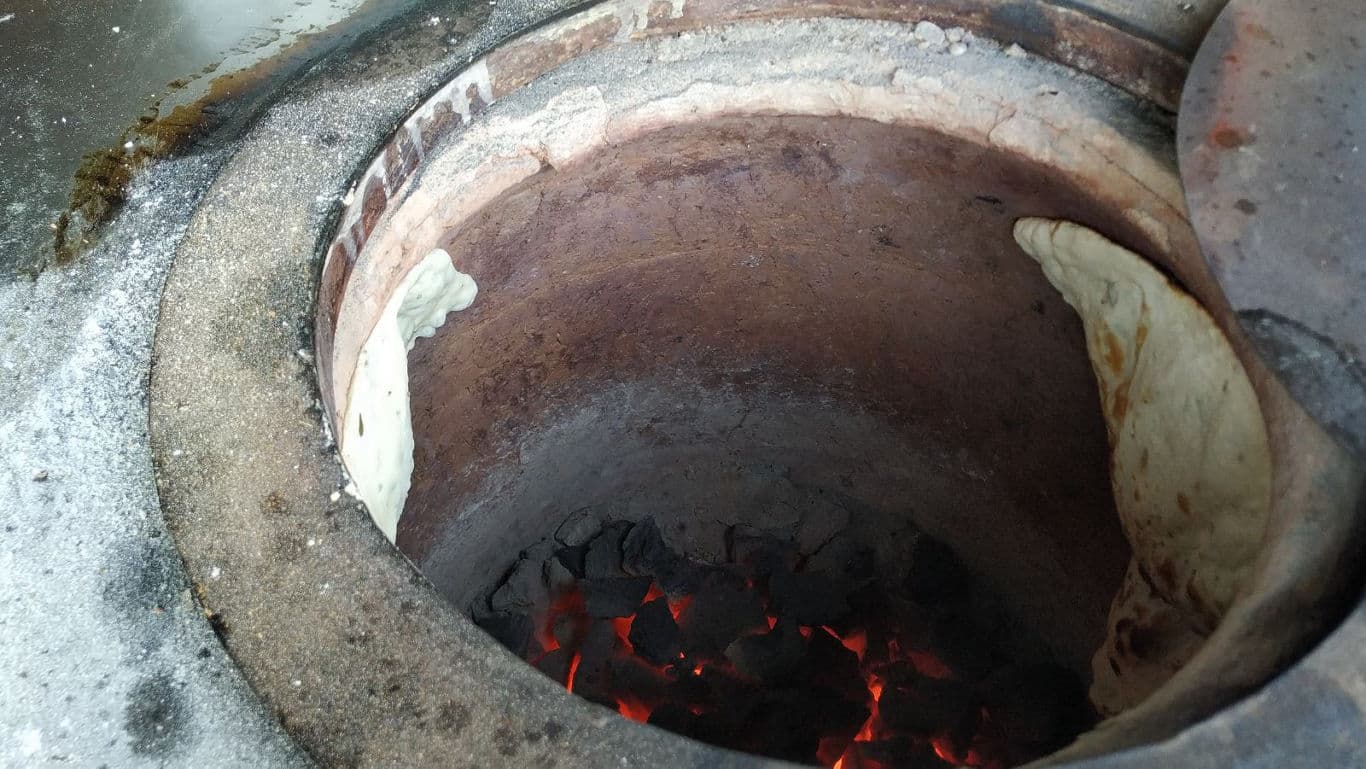 Traditional tandoor oven baking flatbread inside