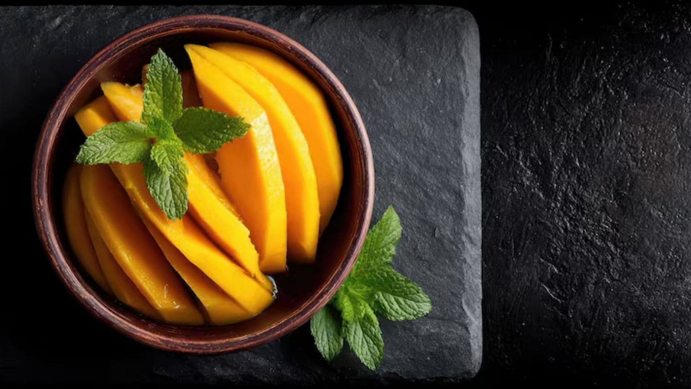 Sliced Fresh Mango in Bowl with Mint Garnish