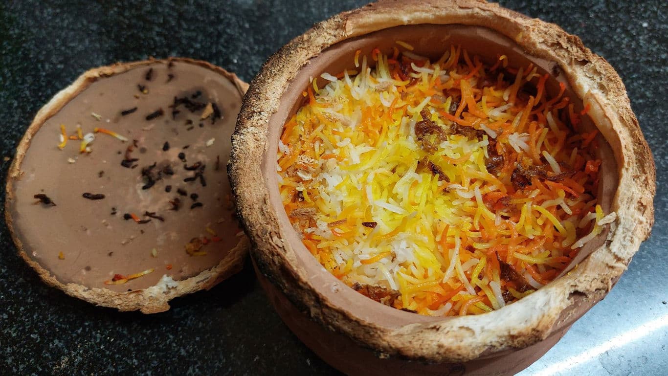 Traditional clay pot biryani with colorful rice layers