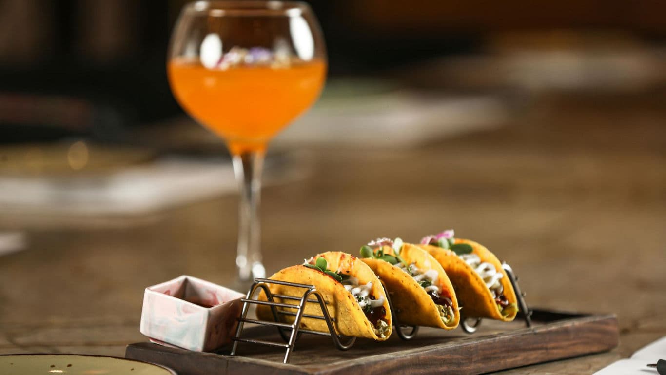 Gourmet tacos served with orange cocktail