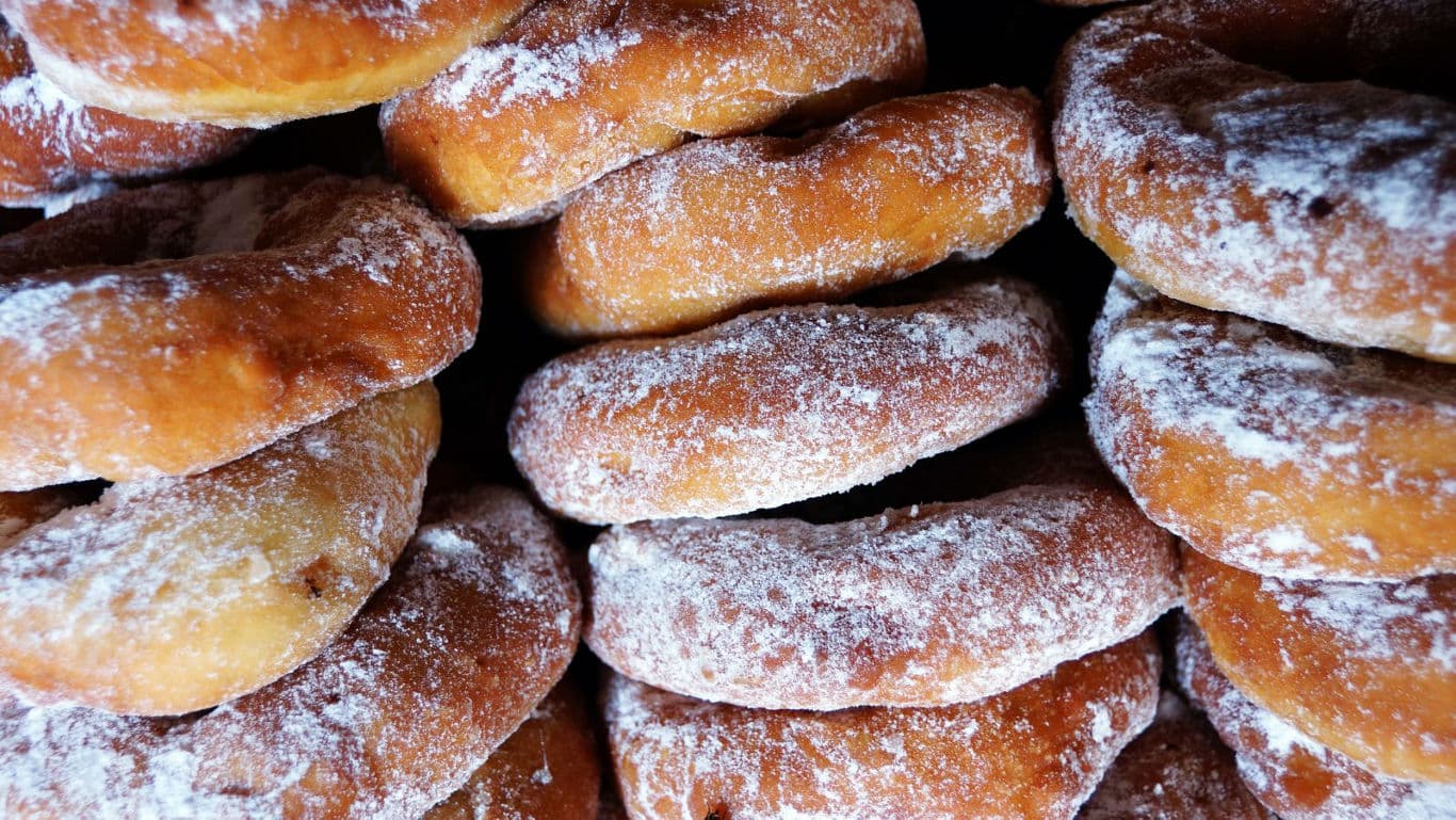 Stacked powdered sugar donuts in closeup