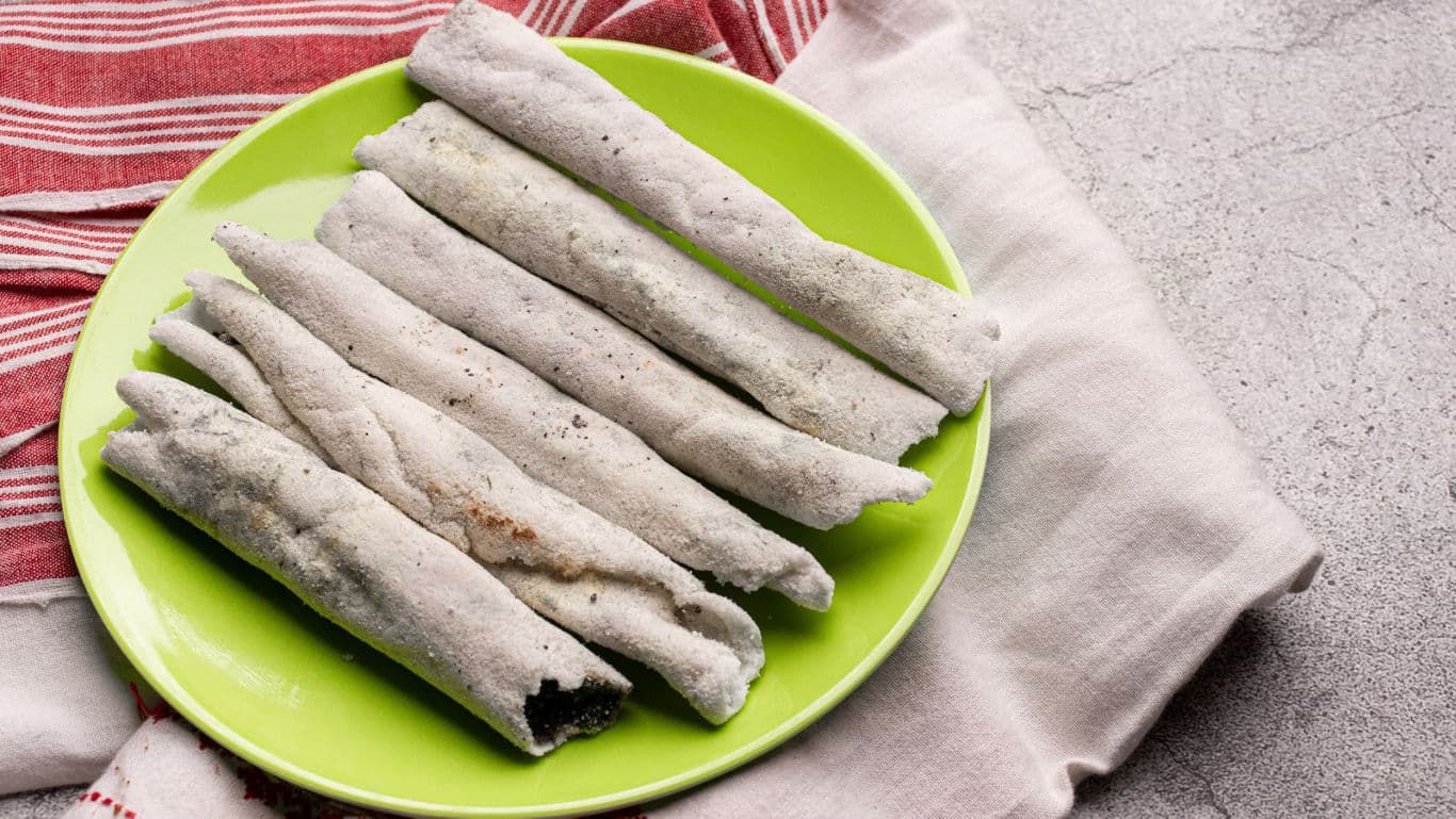 Traditional steamed rice rolls on green plate