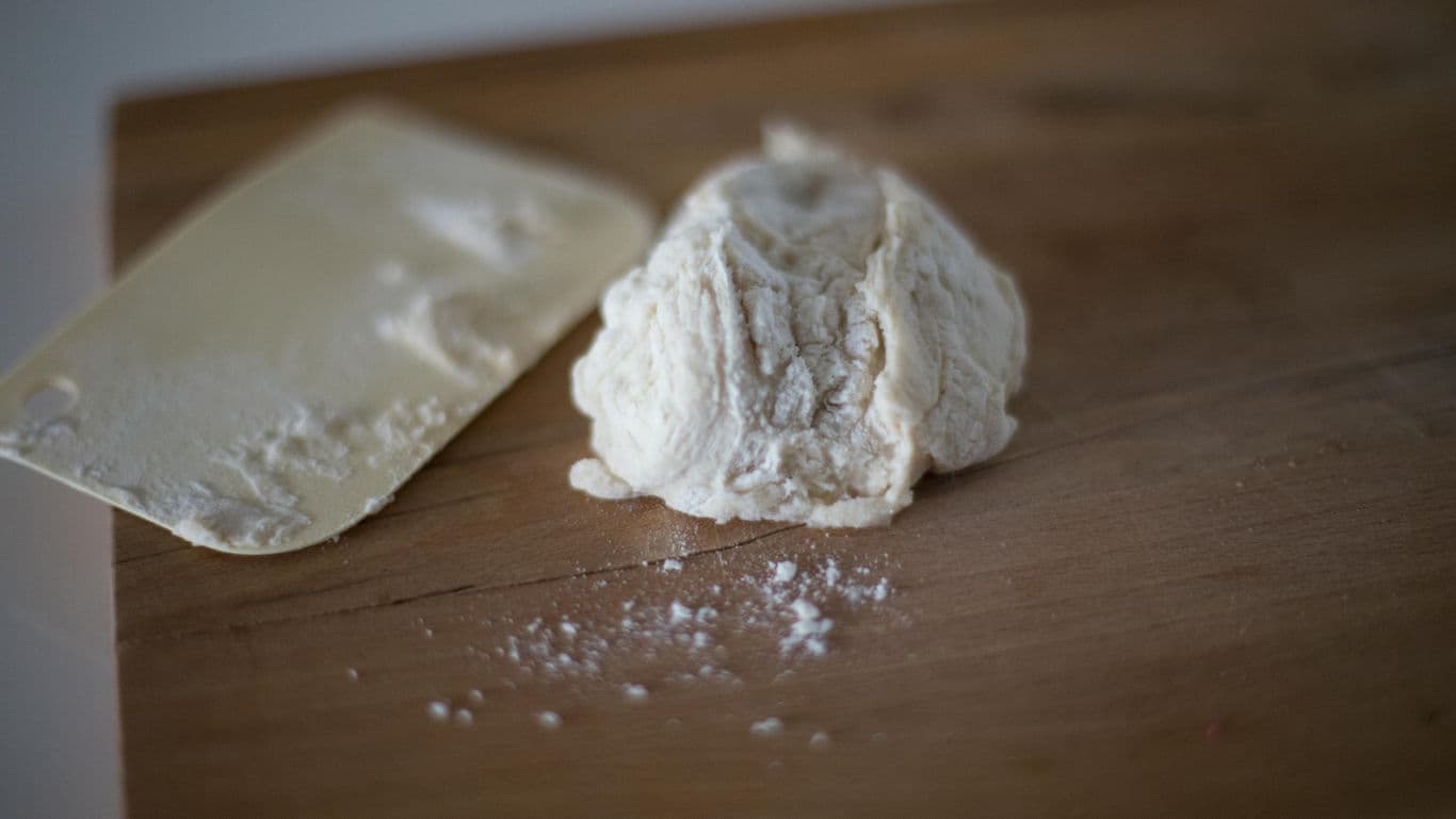 Ball of bread dough on wooden board