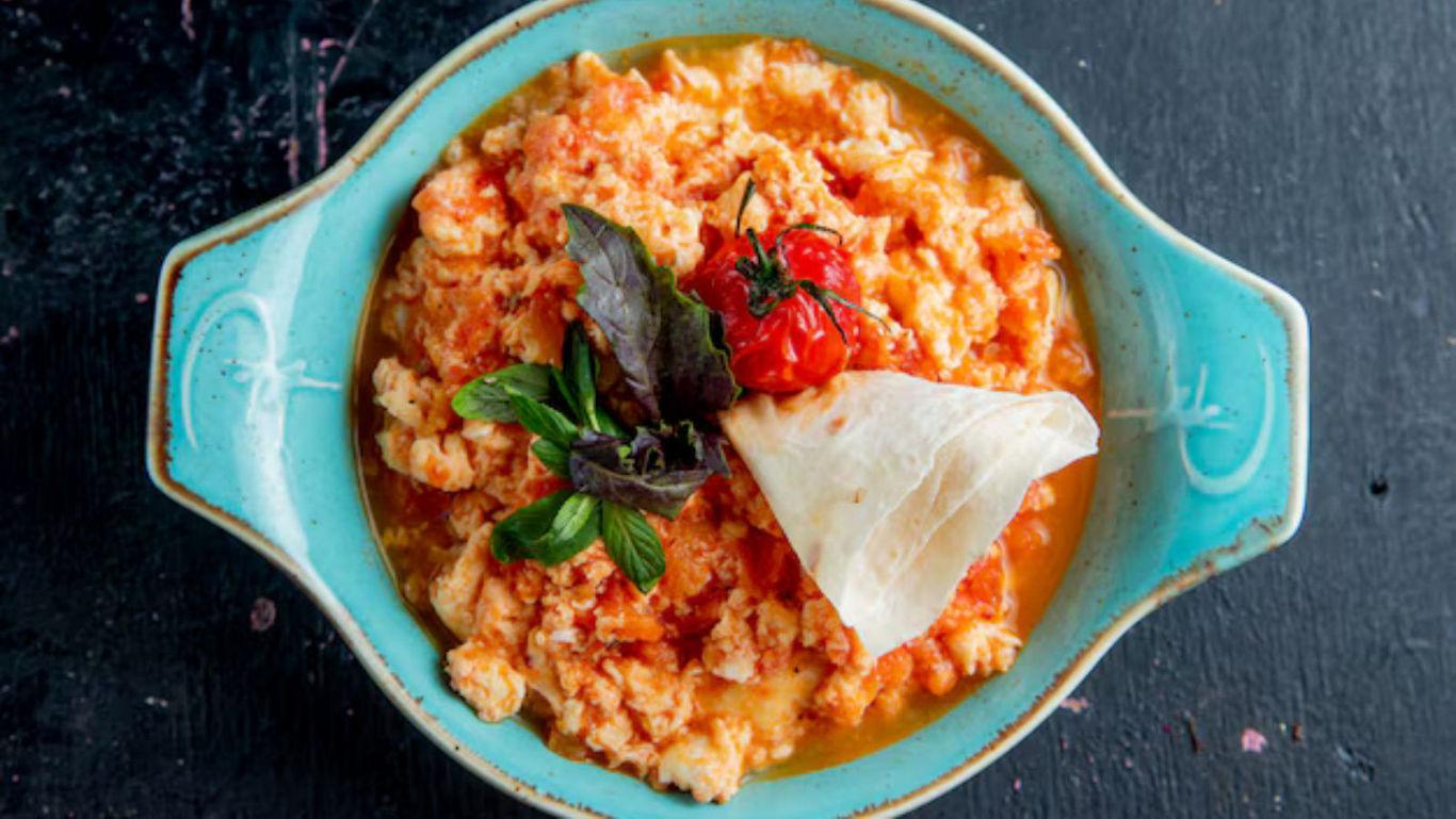 Scrambled eggs with tomato garnish