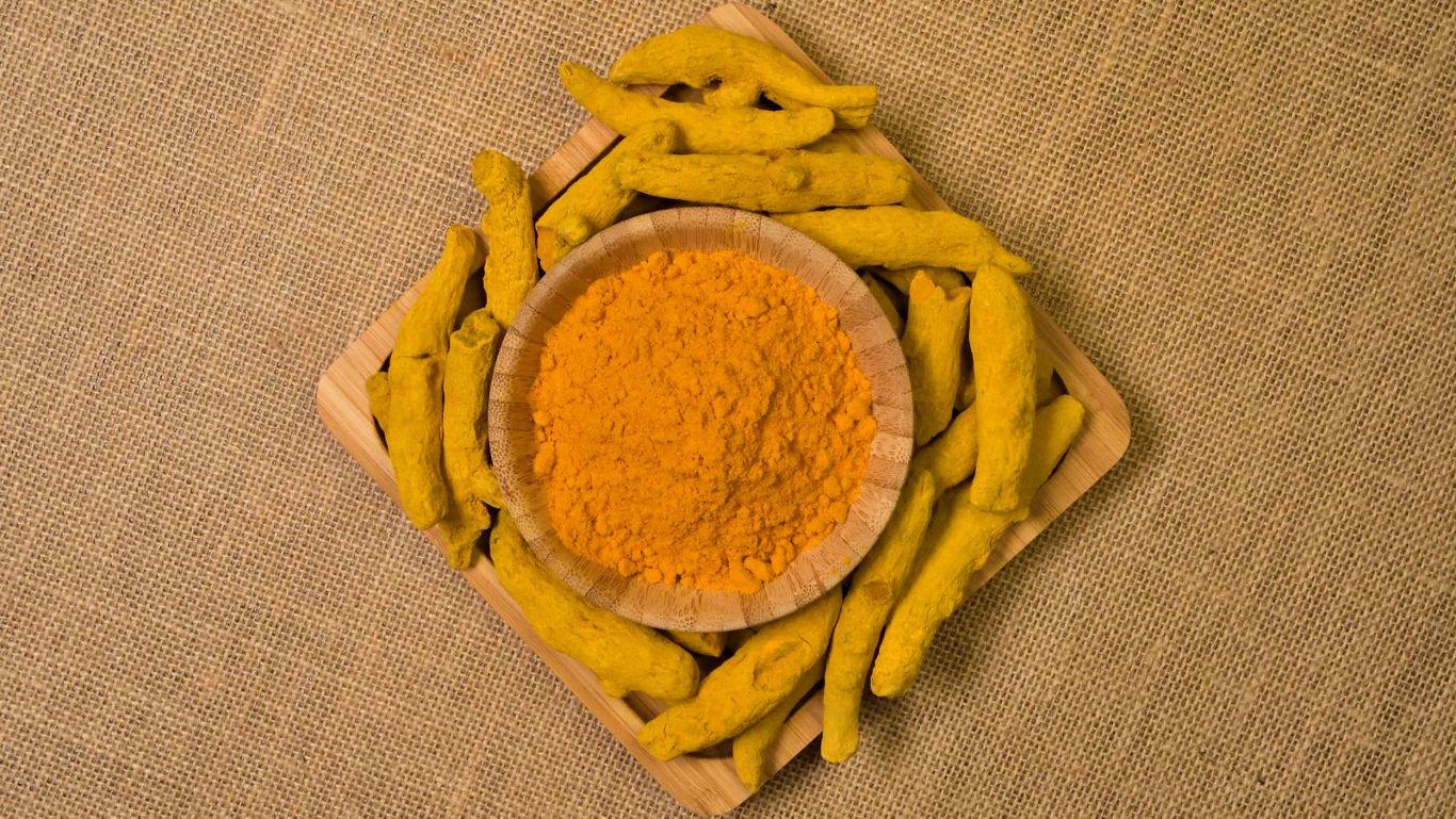 Turmeric roots and powder on burlap