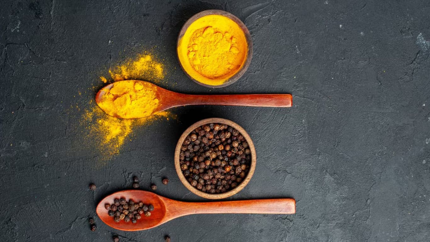 Turmeric and Black Pepper on Dark Background