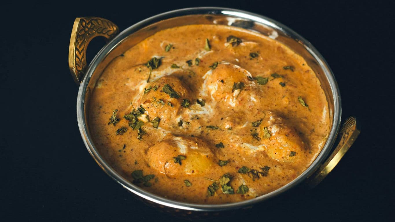 Creamy Indian curry in brass serving bowl