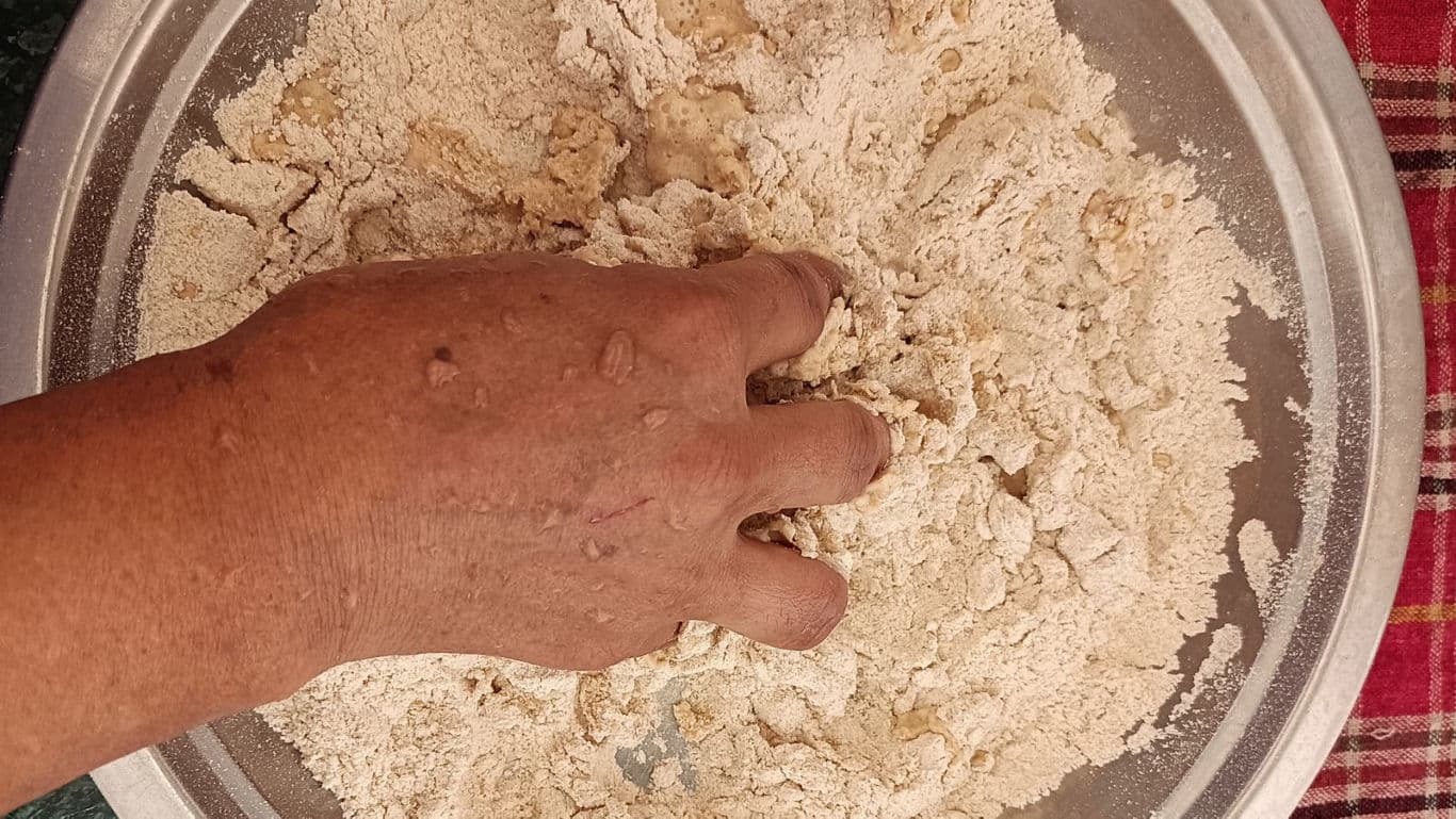 Hand Mixing Flour in Large Metal Bowl