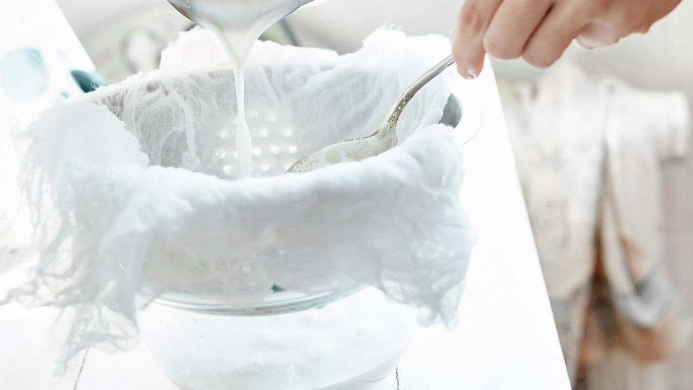 Straining homemade liquid through cheesecloth