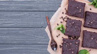 Chocolate brownies with mint on rustic wooden table