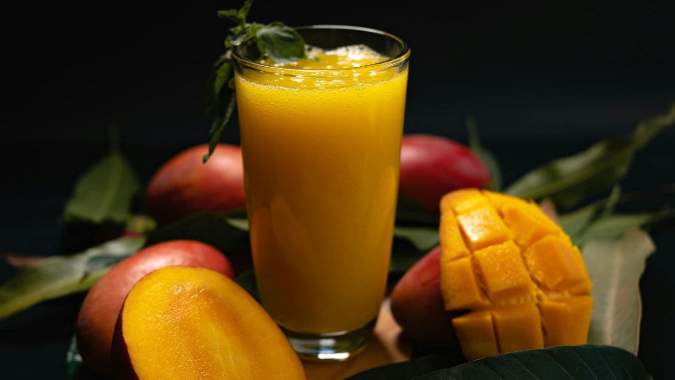Fresh Mango Juice with Sliced Mango on Table
