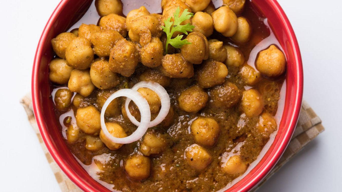 Spiced chickpeas in red bowl with garnish