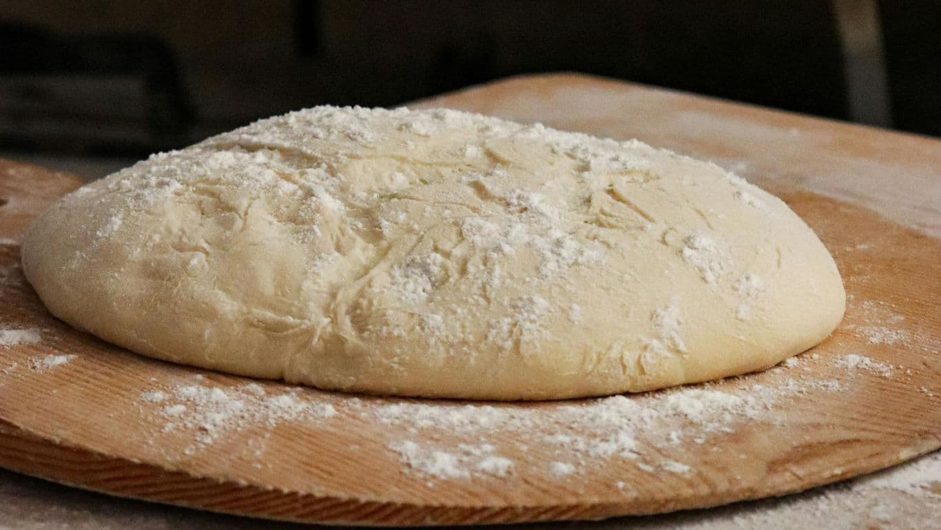 Freshly prepared dough on wooden board