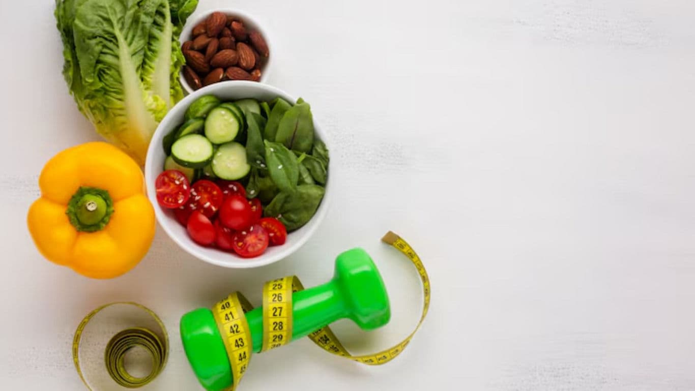 Healthy vegetables, dumbbell, and measuring tape flat lay