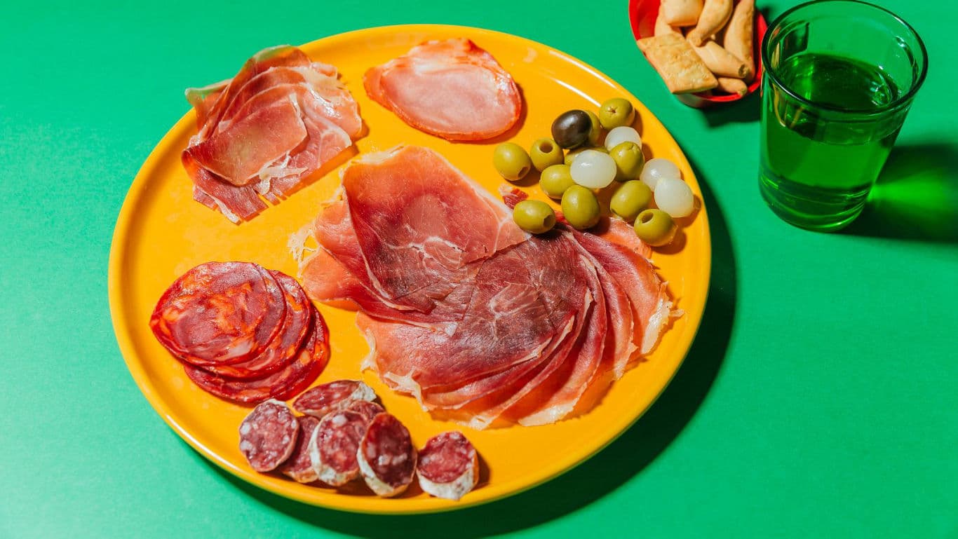 Colorful charcuterie plate with olives and drink