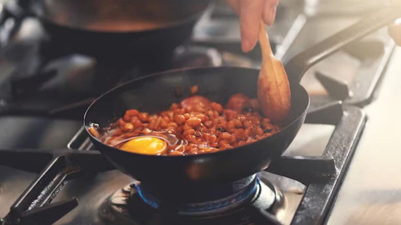 Cooking Beans and Egg in Frying Pan on Stove