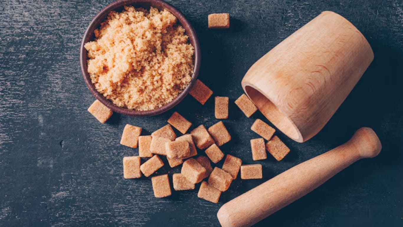 Brown sugar cubes and granules with wooden mortar