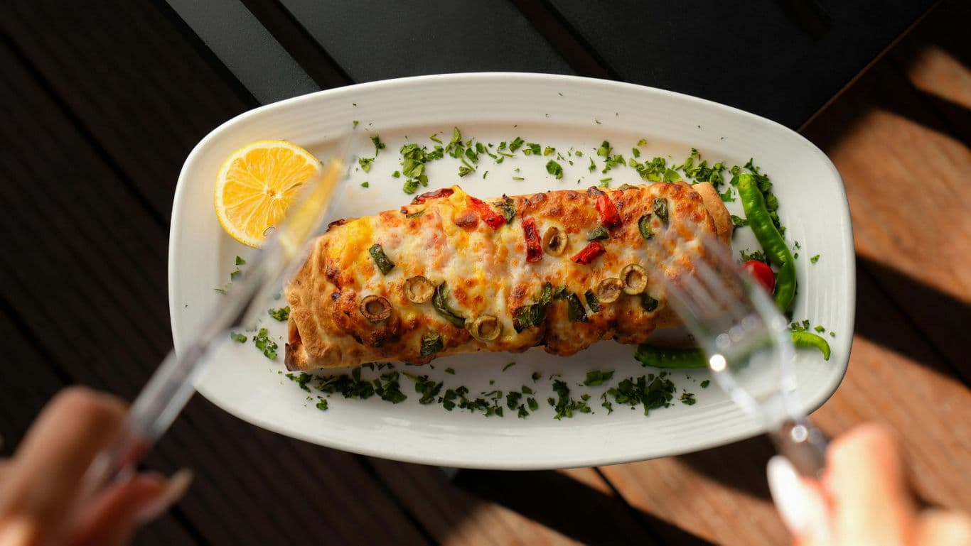 Baked stuffed bread roll with melted cheese and herbs