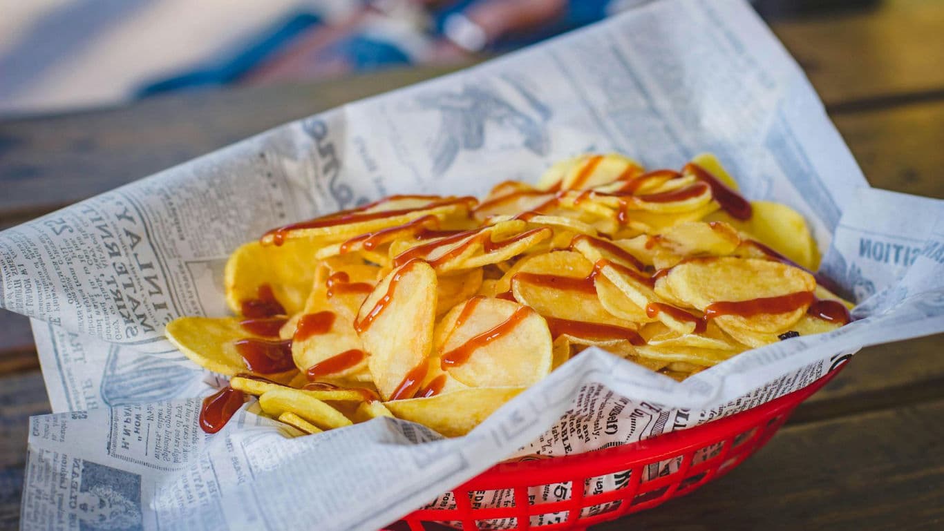 Crispy potato chips with sauce in red basket
