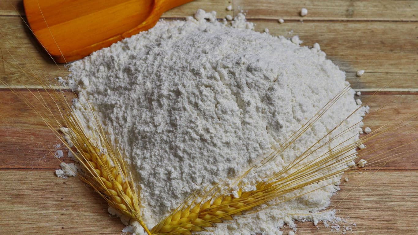 Pile of Wheat Flour with Wooden Scoop on Table