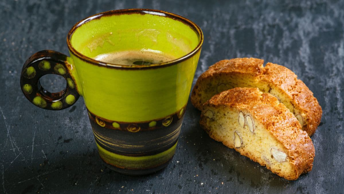 2 biscotti with a green coffee cup