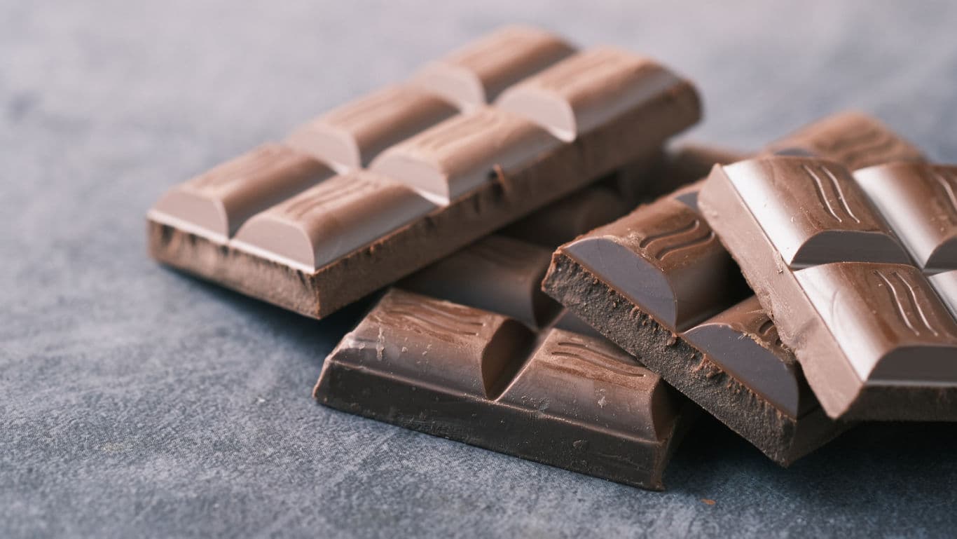 Stacked dark chocolate bars on stone surface