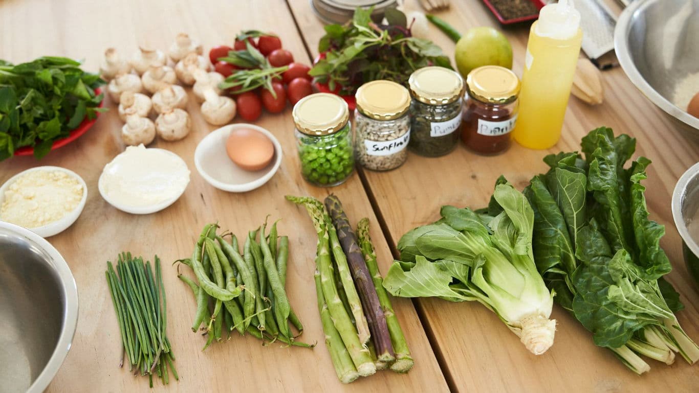 Fresh vegetables and ingredients arranged on wooden table