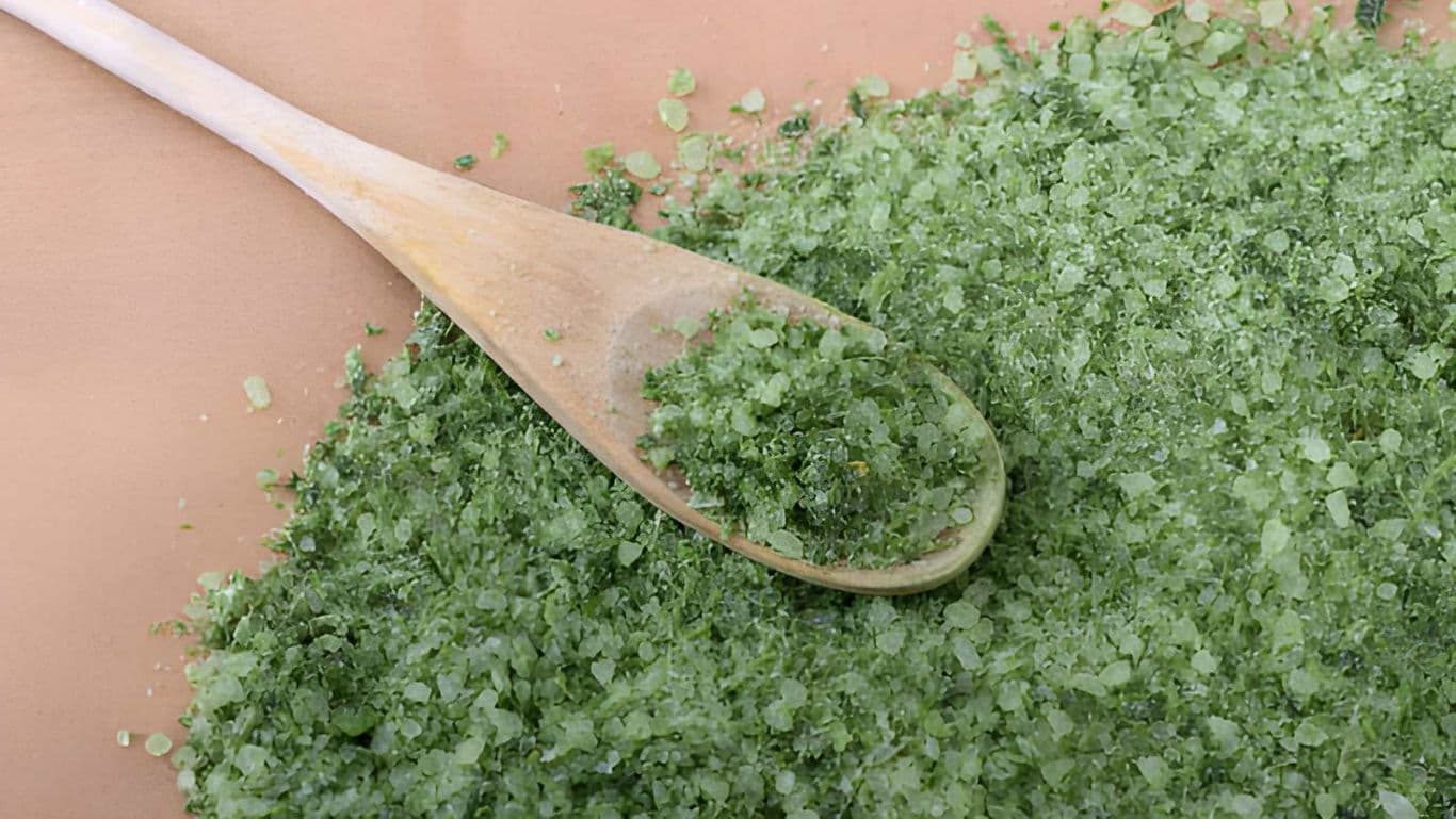 Wooden Spoon with Green Bath Salts on Surface